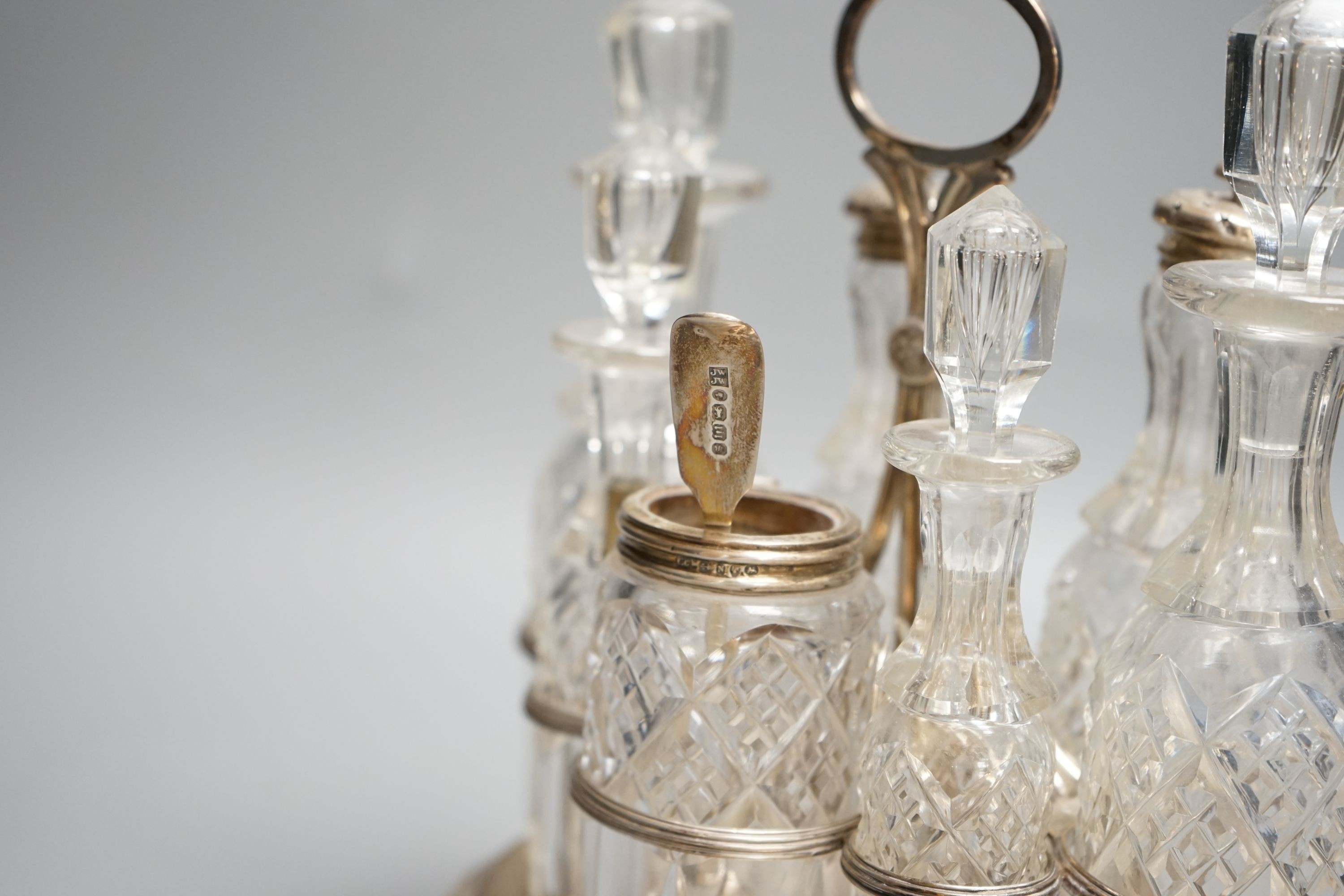 A George III silver oval cruet stand, Henry Nutting, London, 1805, height 25cm, 17.5oz, with six later associated glass bottles.